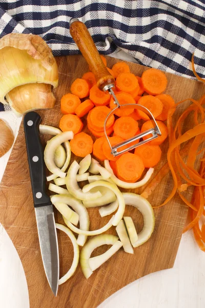 Cebolas preparadas e cenouras em uma tábua de madeira — Fotografia de Stock