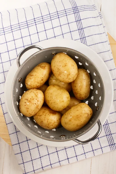 Washed and wet potatoes in a colander — Stock Photo, Image