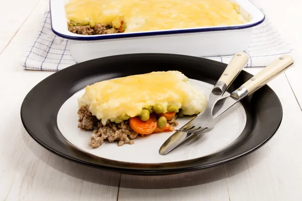 Pastel de pastores irlandeses con queso cheddar derretido en un plato —  Fotos de Stock