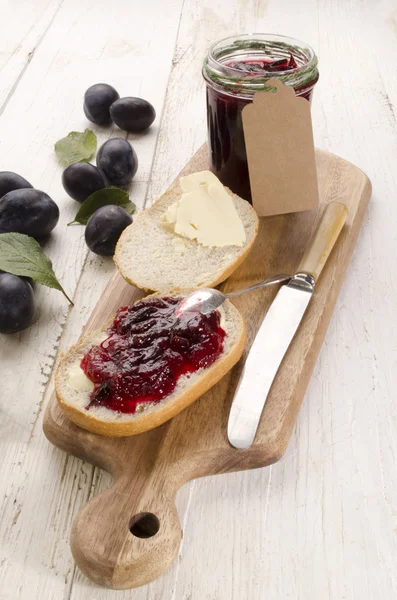 Plum jam on half a bun — Stock Photo, Image