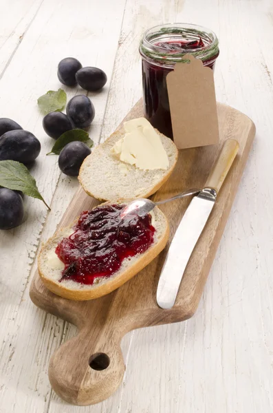 Ontbijt met broodje en pruim jam — Stockfoto