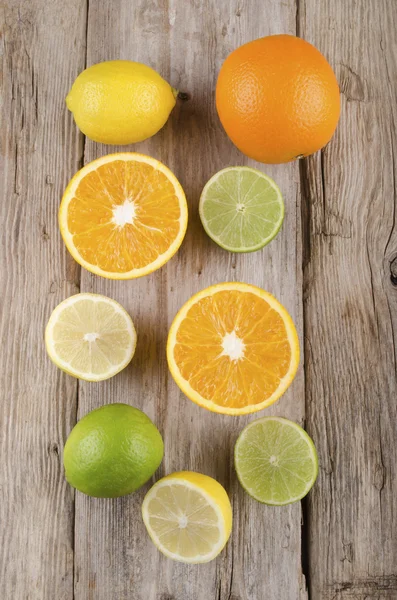 Pomeranče, citrony a limetky na rustikální dřevo — Stock fotografie