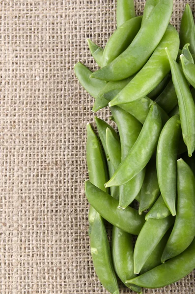 Sugar snap peas på jute — Stockfoto