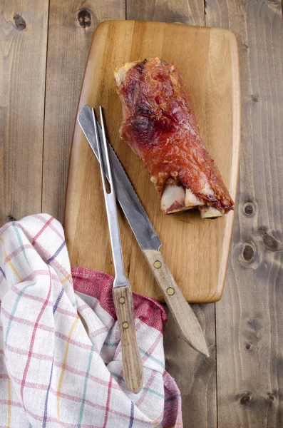 Knuckle of pork on wooden board — Stock Photo, Image