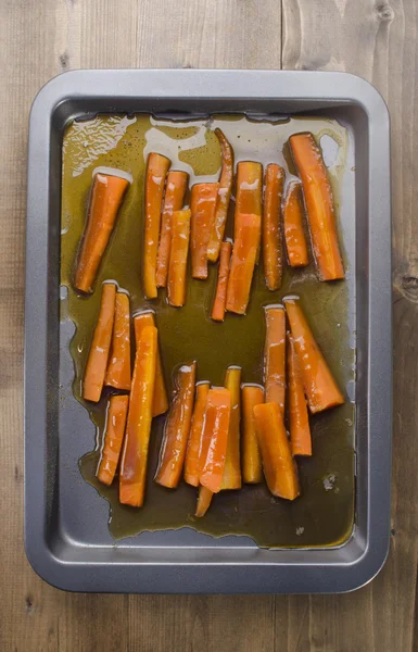 Siroop gekarameliseerde wortelen op bakken lade — Stockfoto
