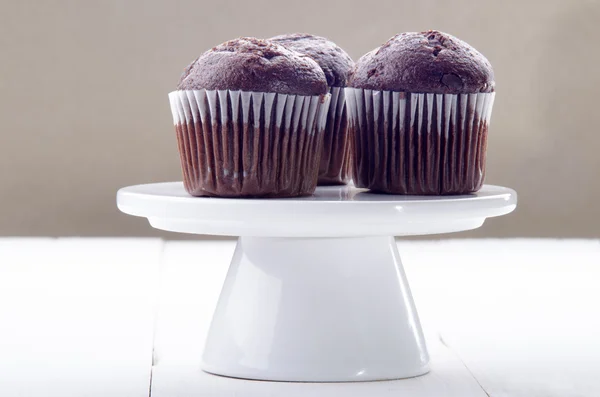 Шоколадный кекс на стенде с белым тортом — стоковое фото