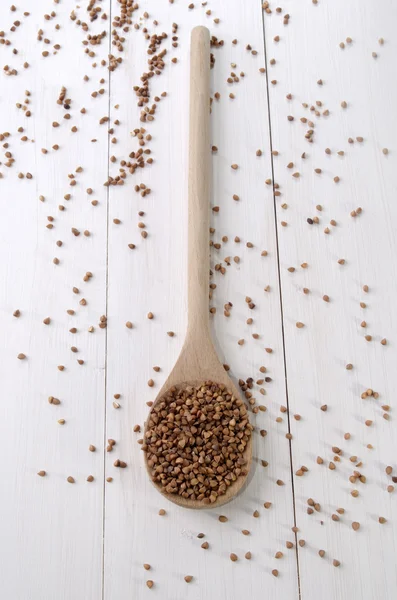 Raw buckwheat on a wooden spoon — Stock Photo, Image