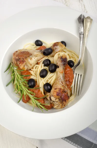 Mediterranean chicken drumsticks on spaghetti — Stock Photo, Image