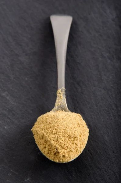 Ground ginger powder on a spoon — Stock Photo, Image