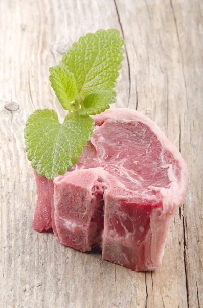 Lamb chop with mint on wood — Stock Photo, Image