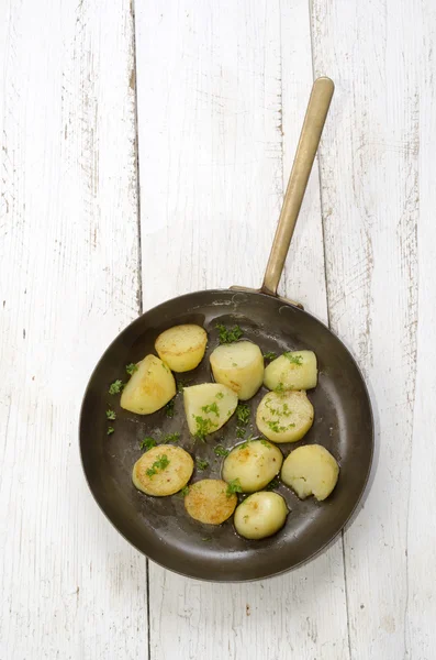 Смажена картопля з петрушкою в мідній сковороді — стокове фото