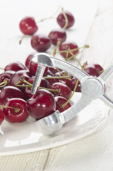 Cherry stone remover and cherries — Stock Photo, Image