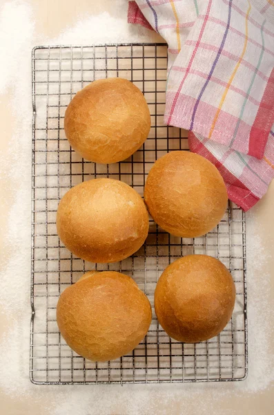 Baked bread rolls on a cooling rack — Stock Photo, Image