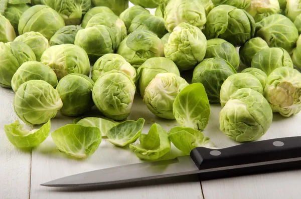 Trimmed brussels sprouts and a kitchen knife — Stock Photo, Image
