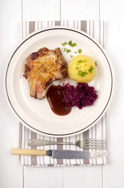 Domuz pirzolası ile kırmızı lahana, sos ve patates hamur tatlısı — Stok fotoğraf