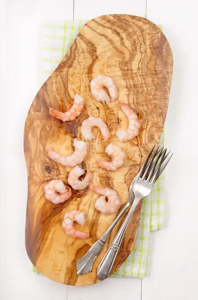 Langostinos y tenedores en una tabla de madera — Foto de Stock