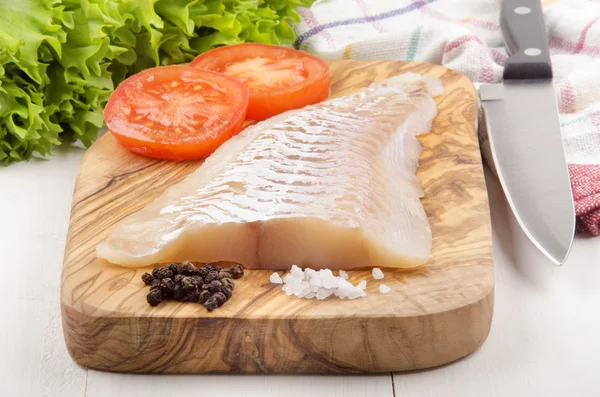 Filete de eglefino en una tabla de madera — Foto de Stock