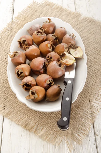 Gedroogde rozenbottels op een plaat met mes — Stockfoto