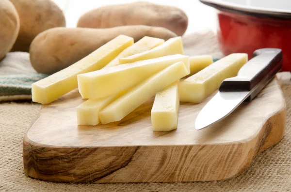 Hemgjorda pommes frites på träskiva — Stockfoto