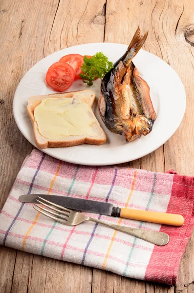 Smoked kipper with bread, sliced tomato and parsley on a plate — Stock Photo, Image