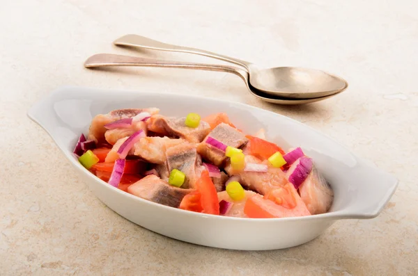 Salada de arenque com cebola lilás, cebolinha e tomate em um arco — Fotografia de Stock