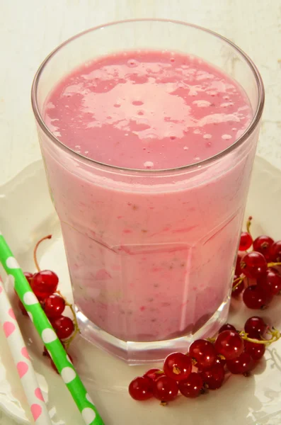 Batido de leite com groselhas vermelhas em um copo — Fotografia de Stock