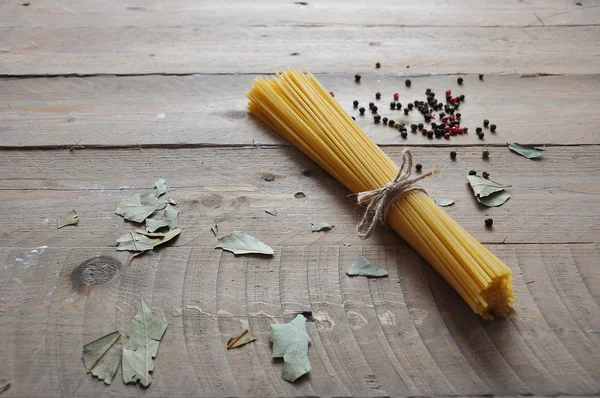 Concepto de cocina. Pastas italianas sin cocer: vermicelli, espaguetis con cordel y tomate sobre fondo de madera —  Fotos de Stock