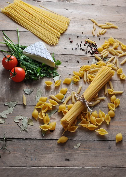 Brie cheese with herbs dill and parsley with different types of spaghetti noodles — Stock Photo, Image