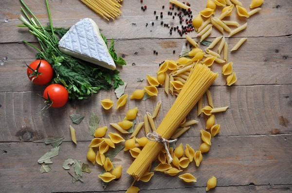 Brie cheese with herbs dill and parsley with different types of spaghetti noodles — Stock Photo, Image