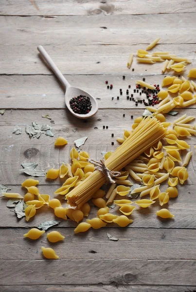 Koken concept. Italiaanse deegwaren: vermicelli, spaghetti met bindgaren op houten achtergrond — Stockfoto