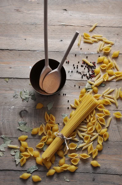 Μαγείρεμα έννοια. Αμαγείρευτα ζυμαρικά ιταλικά: φιδές, Σπαγγέτι με σπάγγο σε ξύλινα φόντο — Φωτογραφία Αρχείου