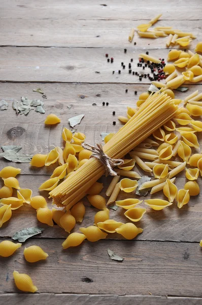 Kochkonzept. Ungekochte italienische Pasta: Vermicelli, Spaghetti mit Bindfaden auf Holzgrund Stockbild