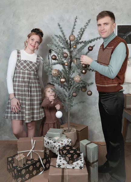 Retro style family decorates the Christmas tree waiting for the Christmas celebratio