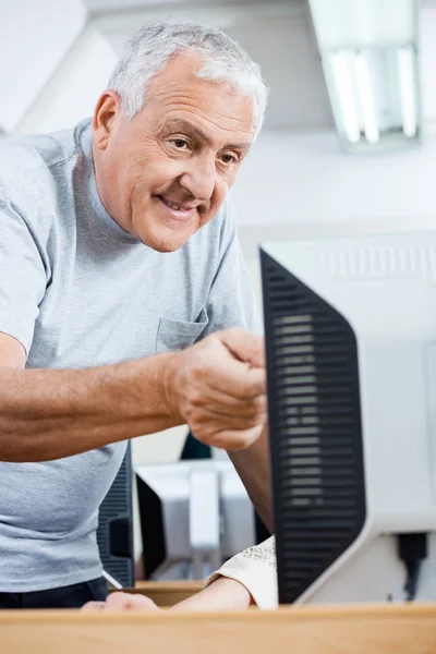 Senior Mann hilft Mitschülerin bei der Nutzung von Computer — Stockfoto
