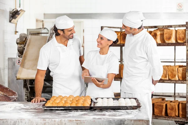 Bakkers kijken elkaar tijdens het gebruik van digitale Tablet — Stockfoto