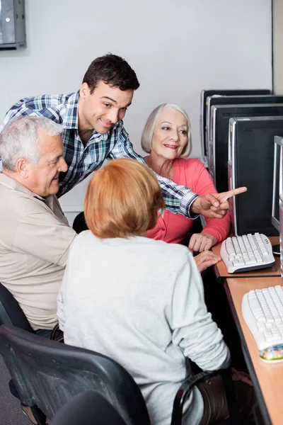 Professor Assistindo Pessoas Idosas no Uso de Computador na Sala de Aula — Fotografia de Stock