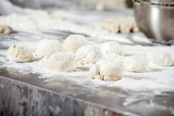 Bolas de masa cubiertas con harina en la mesa — Foto de Stock