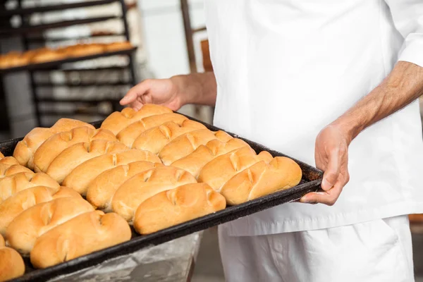 Στη μέση του Baker μεταφέρουν ψωμιά στο ταψί ψησίματος — Φωτογραφία Αρχείου