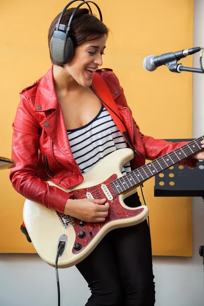 Happy podepisující hraje na kytaru v nahrávání Studio — Stock fotografie