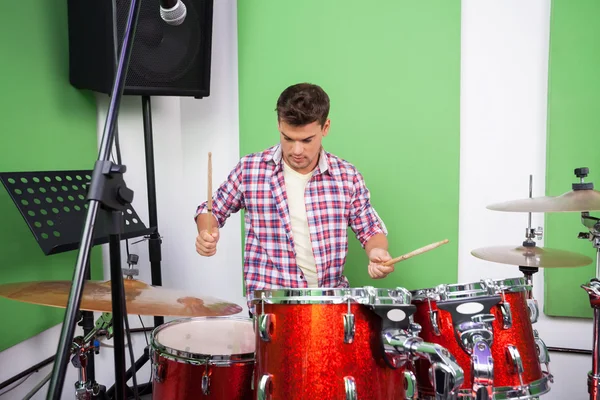 Музыканты играют на барабанах в студии звукозаписи — стоковое фото