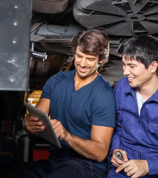 Mechanics Using Digital Tablet Under Car — Stock Photo, Image