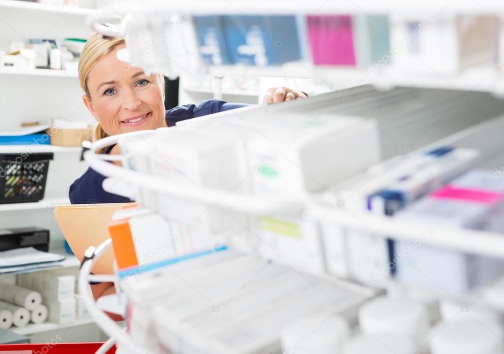 Female Chemist Counting Stock In Pharmacy