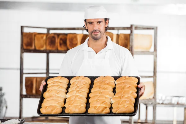 Αυτοπεποίθηση Baker δείχνει ψωμιά στο ταψί ψησίματος — Φωτογραφία Αρχείου