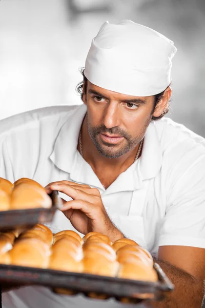 Мужчина Бейкер Холдинг хлебопекарные подносы в пекарне — стоковое фото