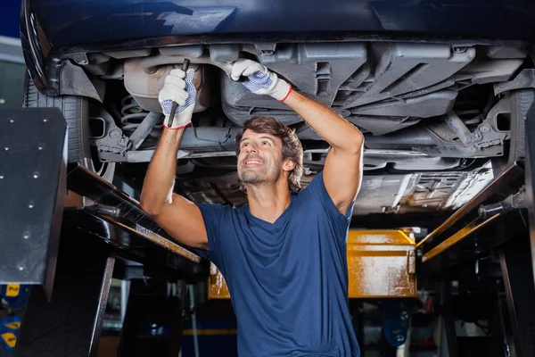 Mechaniker repariert unter Auto — Stockfoto