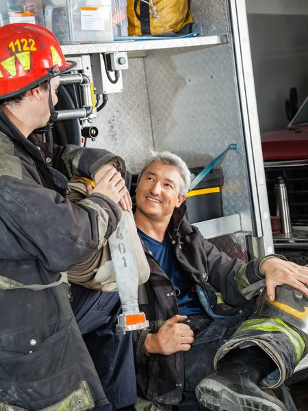 Brandweerman bespreken met collega op vrachtwagen — Stockfoto