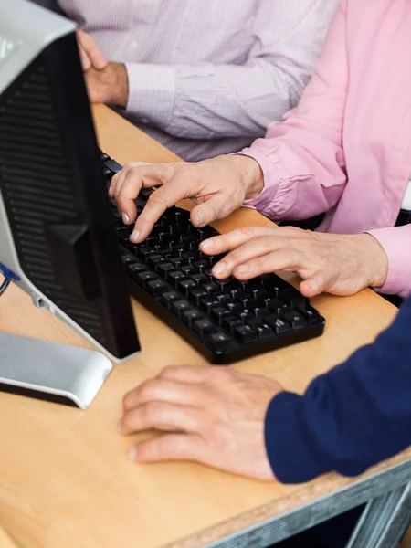 Étudiants seniors et tuteur au bureau en classe d'informatique — Photo