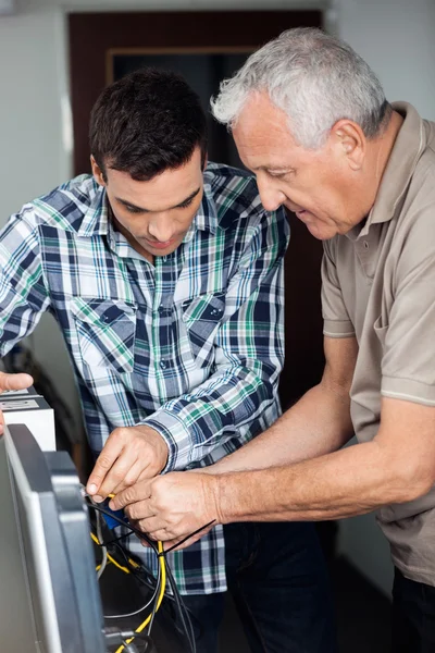 Tutor und Senior-Mann reparieren Computer im Unterricht — Stockfoto
