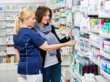 Phar içinde cep telefonu tutan kadın için ürünlerini gösteren Yardımcısı