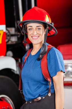 Gülümseyen Firewoman kırmızı kask giyiyor